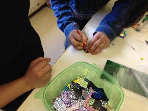 Jasmine demonstrates cutting glass to another student